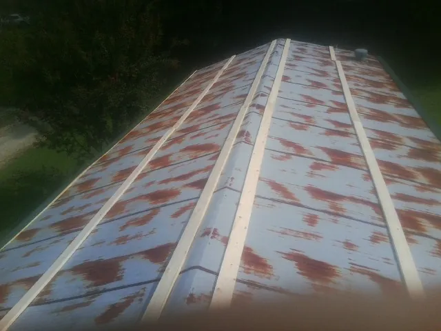 Rusted metal roof panels with new wood purlins before replacement — Storm Damage Roof Repair in Jonesville by Roofing Brothers