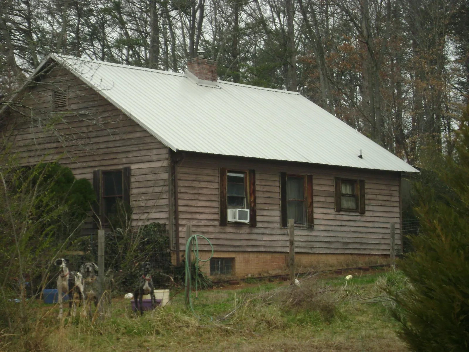 White metal roof on an old wood sided farmhouse, from a Metal Roof Installation job in Jonesville